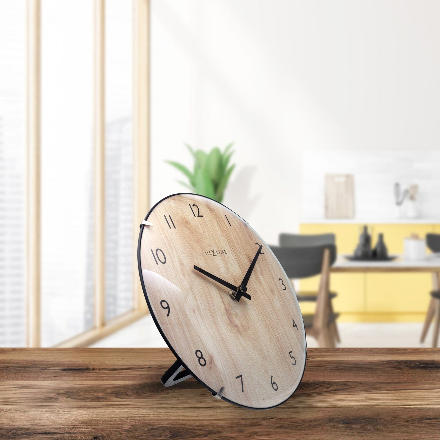 Een ronde houten wandklok met zwart metalen rand en wijzers, voor een minimalistische woonkamer. De lichte eikenhouten achtergrond heeft duidelijke houtstructuur en het merk 'NEXTIME' in het midden.