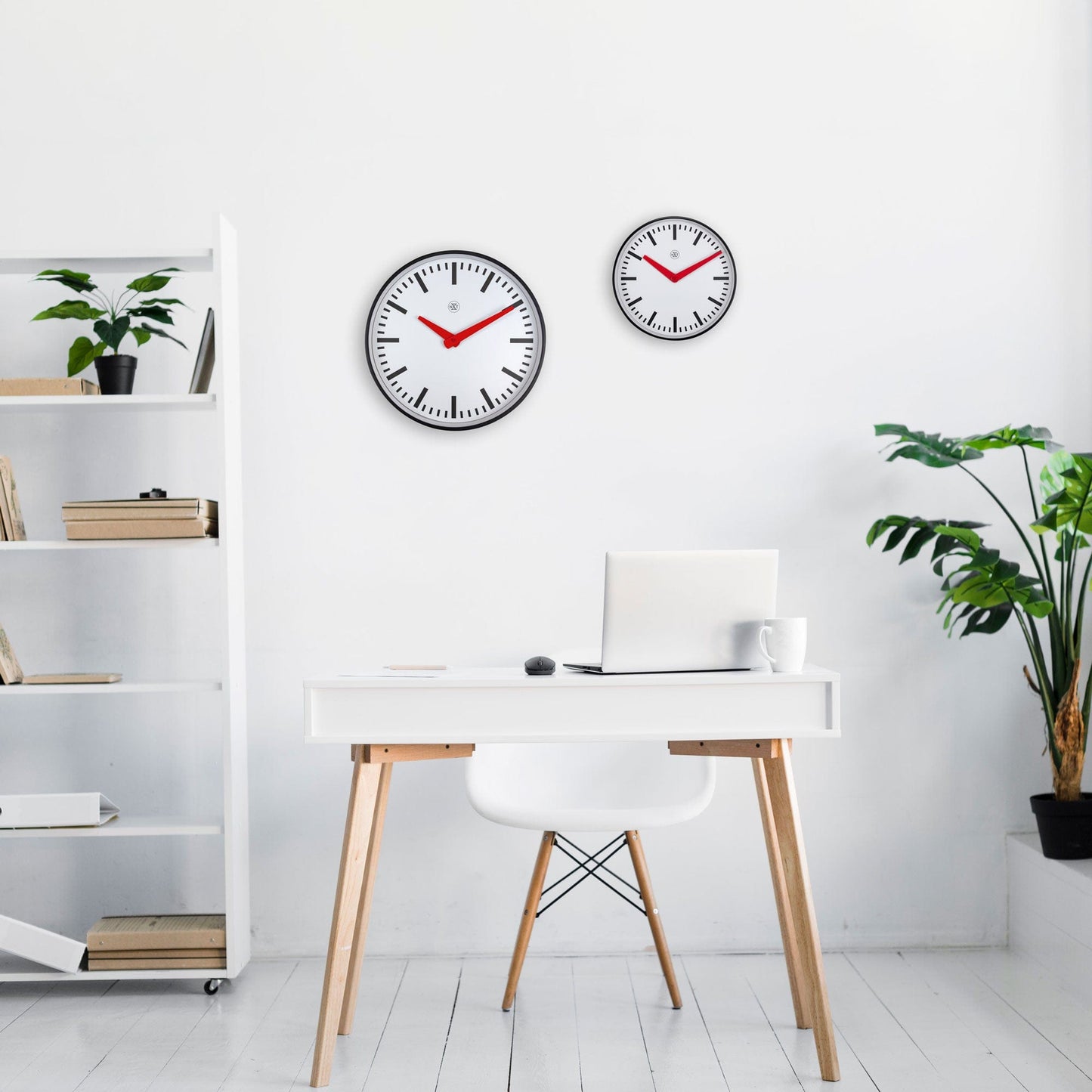 Een moderne wandklok met witte wijzerplaat, zwarte markeringen en opvallende rode wijzers. Zilveren rand en minimalistisch ontwerp voor een stijlvolle kamerdecoratie of kantooromgeving.