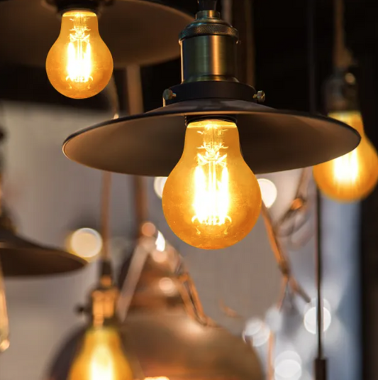 Zwarte glazen gloeilampen met warm wit licht en zichtbare filamenten, voorzien van een zilverkleurige E27-schroefdraad. Perfect voor vintage interieurs en sfeerverlichting.