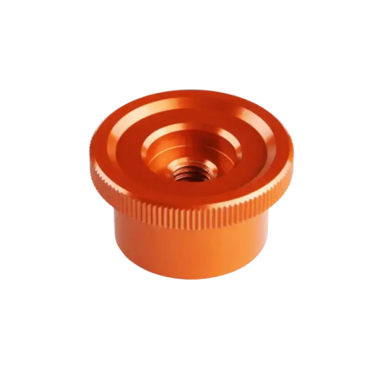 Oranje aluminium onderdeel met ribbelrand en schroefgat, geschikt voor 3D-printers. Grote, glanzende cilinder met precisiegeboorde opening voor montage.