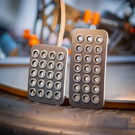 Zwarte, rechthoekige kabelorganizers met 24 gaten, geschikt voor kabelbeheer. Gemaakt van flexibel rubber, ideaal voor kabelorganisatie in kantoor- en thuisomgevingen.