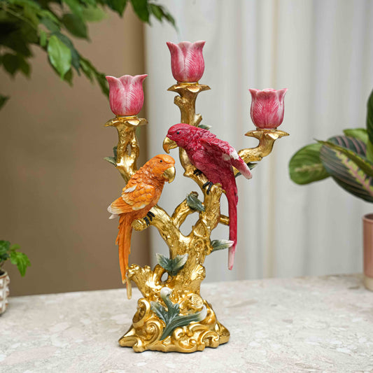 Gouden kandelaar met twee kleurrijke papegaaien en roze tulpen, geschikt als decoratie voor woonkamer of tafel. Prachtige detailwerk en glanzende afwerking voor een elegante interieurverlichting.