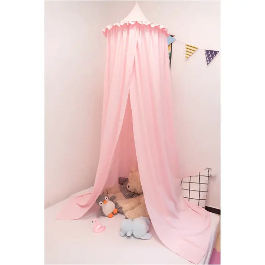 Een witte, lichte kindermoskitonkel met ruches hangt boven een speelkamer, omringd door knuffels en een gestreept kussen. Ideaal voor baby’s en kinderen in slaapkamers of speelruimtes.