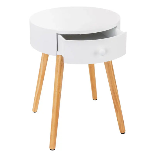 Een wit nachtkastje met één lade en een ronde knop, ondersteund door vier houten poten. Geschikt als nachtkastje of bijzettafel in een moderne slaapkamer.