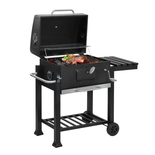 Zwarte, mobiele gaskachels met zilveren handgrepen en wielen, geschikt voor buitenkeuken. Met aanhangtje en haken voor gereedschap, ideaal voor barbecue-avonden.
