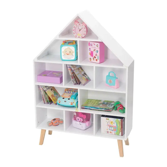 Een wit, huisvormig kinderboekenkastje met houten poten, gevuld met kleurrijke boeken, speelgoed en letters. Ideaal voor een kinderkamer of speelruimte.