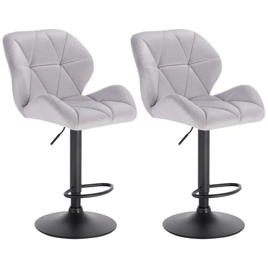 Donkergroene, fluweelbeklede barstoelen met diamantvormige bekleding en zwarte metalen poten, geschikt voor moderne keukens of bars. Comfortabele zitvlakken met verstelbare hoogte en stabiliserende voet.