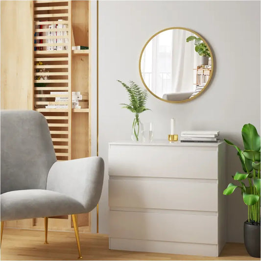 Gouden ronde spiegel met glanzende rand, weerspiegelt een kamer met witte gordijnen, een houten deur en groene planten. Perfect voor woonkamer of slaapkamerdecoratie.