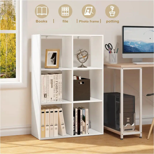 Een witte, modulare boekenkast met zes vakken, gevuld met boeken, mapjes, schaar en een mandje. Ideaal voor kantoororganisatie of huiselijke opbergruimte.