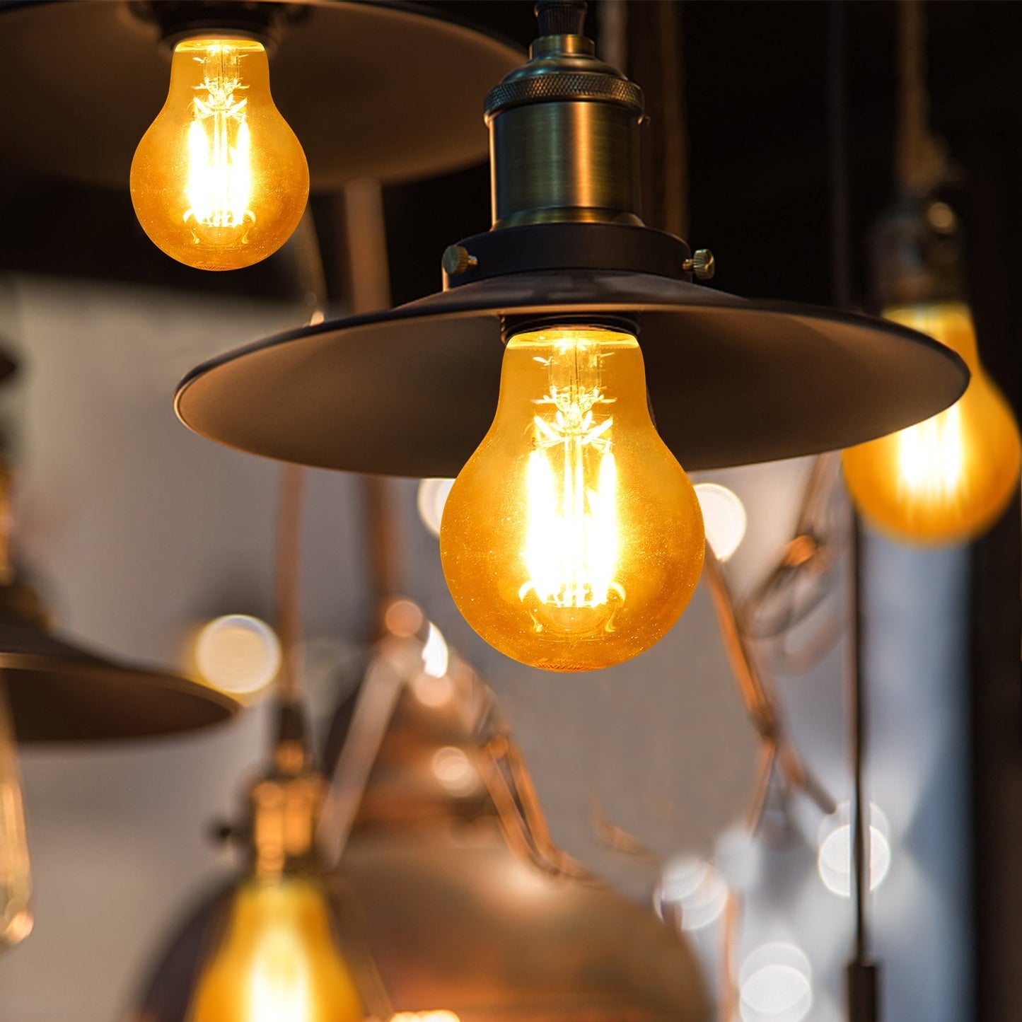 Zes glazen filamentlampen met warme witte gloed en zichtbare koperen draden, geplaatst op een witte achtergrond. Perfect voor vintage interieurs en sfeerverlichting.
