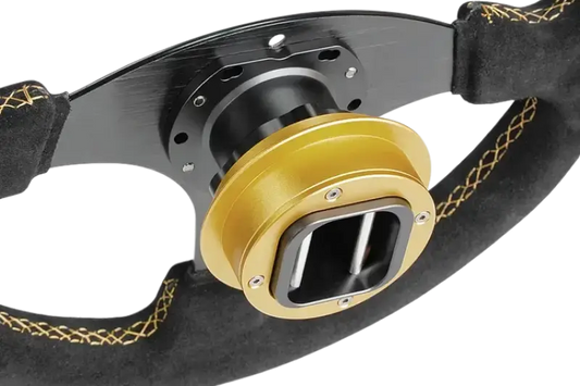 Gouden metaalonderdeel met zwart plastic kast en zichtbare metalen staven, geschikt voor industriële toepassingen. Zwart flange onderkant voor montage in machines of installaties.