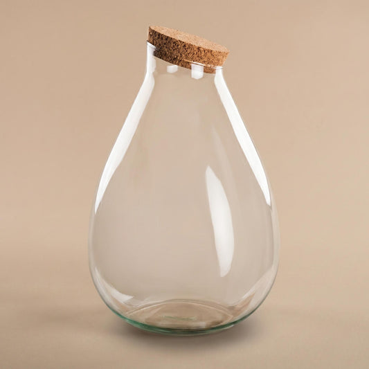 Een transparante glazen fles met een natuurlijke kurkstop, geschikt voor het opslaan van droge kruiden of als decoratief element in de keuken. Perfect voor het opbergen van kruiden of als stijlvolle decoratie.