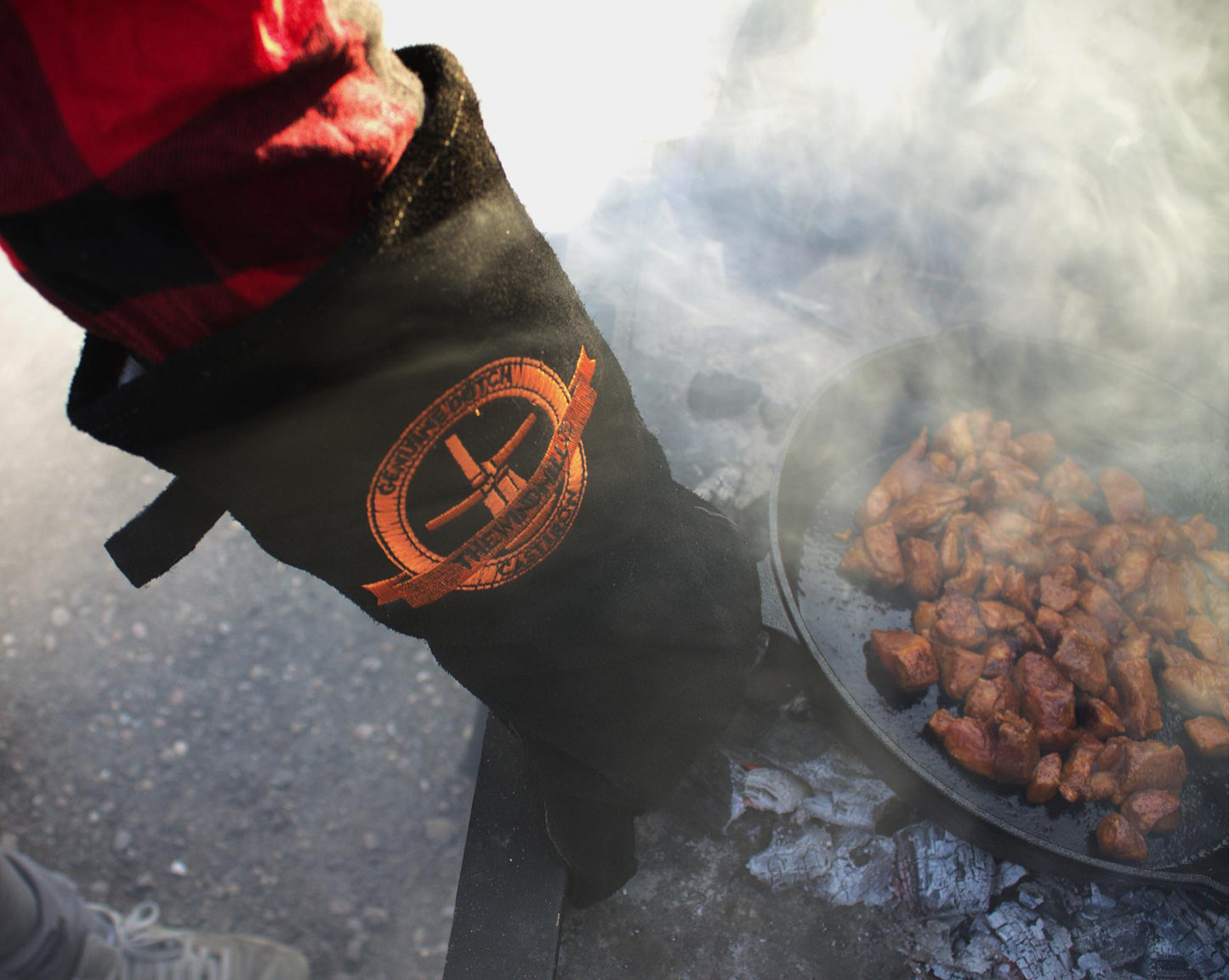 Zwarte leerhandschoenen met opgestikte goudkleurige logo, geschikt voor werken met warmte en hoge temperatuur. Zichtbare naadwerk en zachte textuur voor betere grip en bescherming.