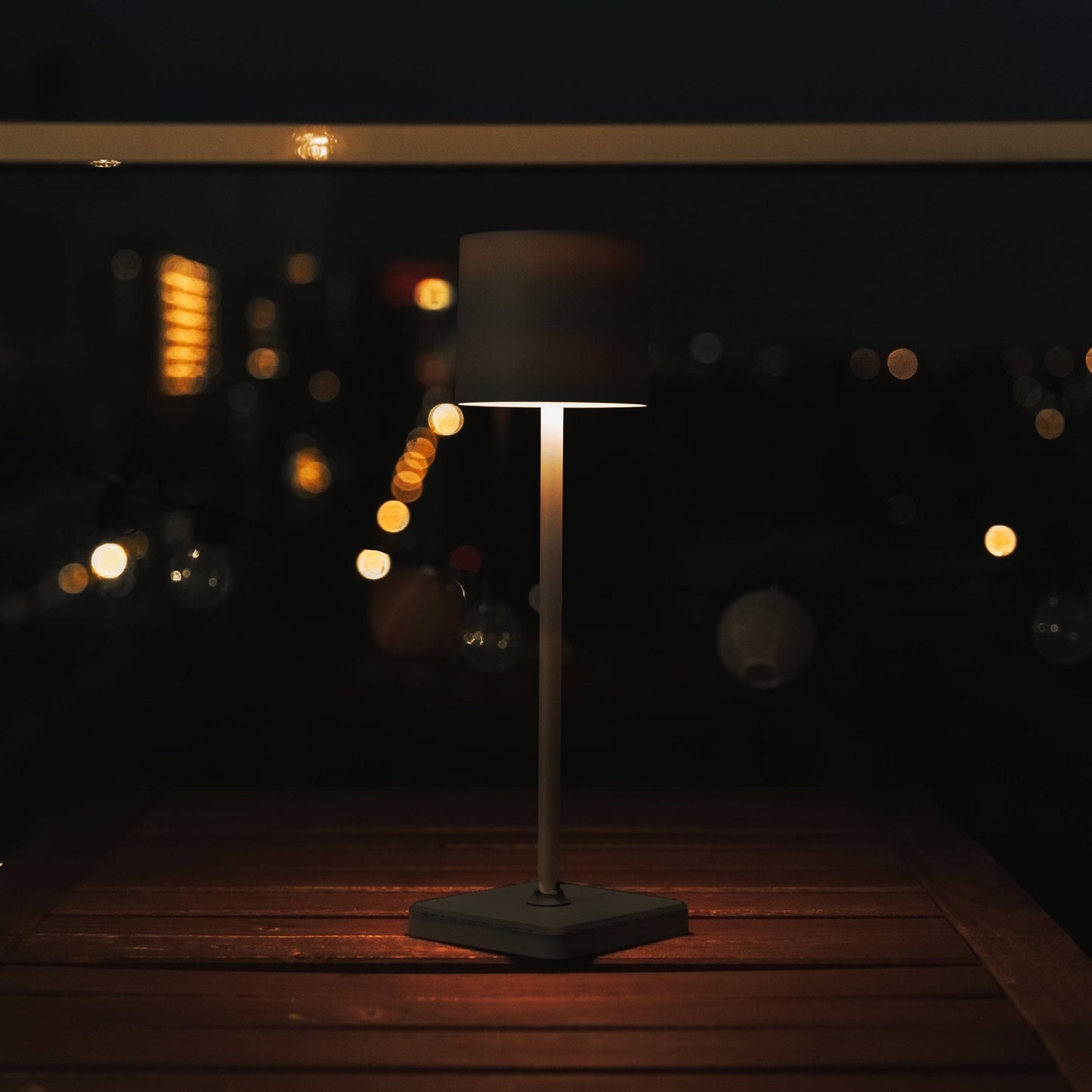 Zwarte staand lamp met mat zwart textiel kap en vierkante voet, uitgerust met USB-oplaadbare basis voor nachtlicht of sfeerverlichting in slaapkamer of woonkamer.