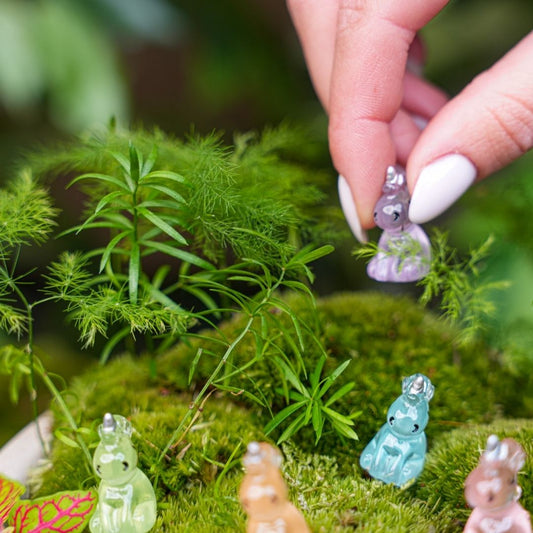 Zes kleurrijke glazen eenhoornfiguren in pastelkleuren, elk met een zilveren hoorn en gesloten ogen, perfect voor kinderkamerdecoratie of als speelgoed voor jonge kinderen.