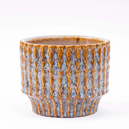 Een ronde, handgemaakte keramische plantenpot met een textuur van golvende, goudbruine en blauwe glazuur. Perfect voor binnen- en buitenruimtes als decoratieve plantenbak.