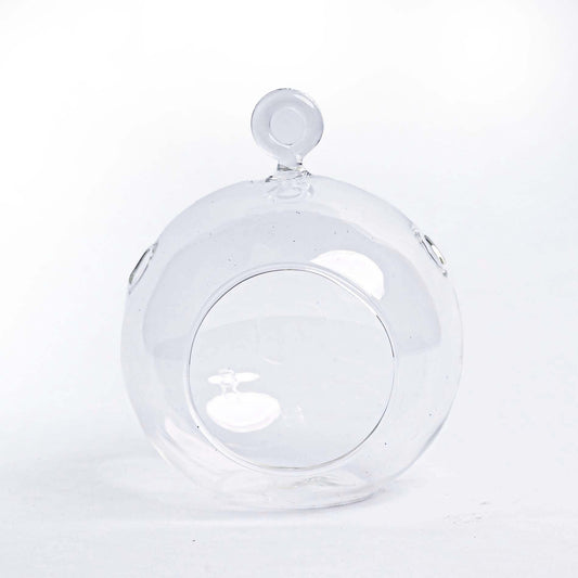 Glasballen met groene mos en dennenappels hangen aan een kerstboom, versierd met lichtjes. Perfecte decoratie voor een duurzame, natuurlijke kerstboomversiering.