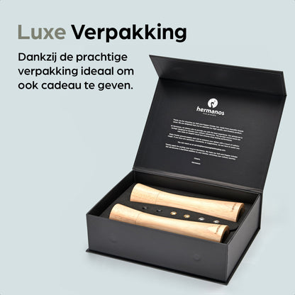 Houten pepermolen en zoutmolen van Hermanos, met goudkleurige doppen en FSC-certificering, geplaatst op een houten standaard met vervangbare doppen voor keukengebruik.