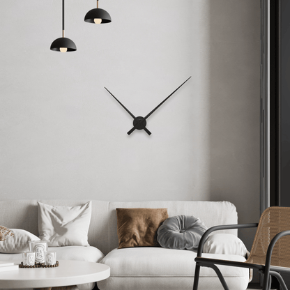 Een minimalistisch zwart wandklok met dunne, gestileerde wijzers en een ronde centrale plaat. Perfect voor moderne interieurs en als decoratief element in woon- of kantoorruimtes.
