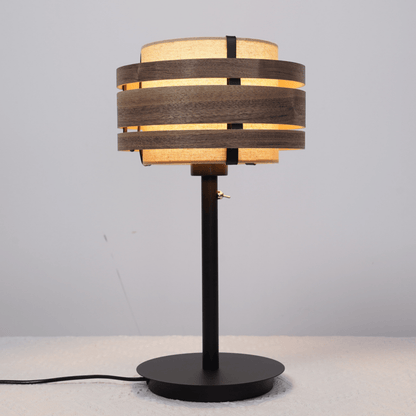 Een moderne wandlamp met donker houten ringen en lichtbeige stoffen kap, voor een warme sfeer in woonkamer of slaapkamer. Geschikt voor minimalistische interieurs en als accentverlichting.