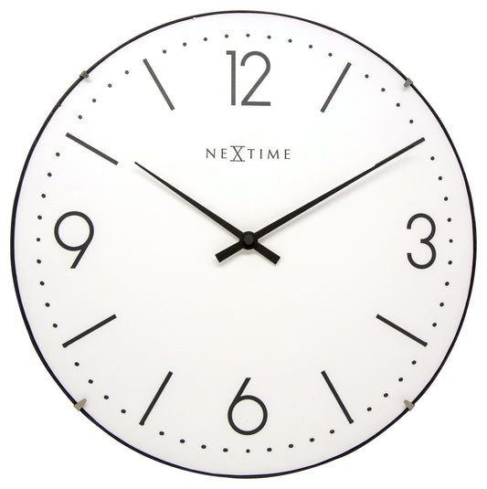 Een minimalistische witte wandklok van Nextime met zwarte cijfers en wijzers, geschikt voor moderne interieurs. Geschikt voor woonkamer of kantoor, met een schone, tijdloze esthetiek.