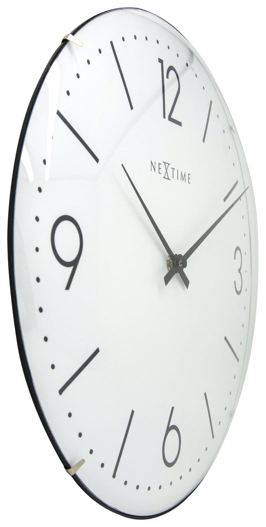 Een minimalistische witte wandklok van Nextime met zwarte cijfers en wijzers, geschikt voor moderne interieurs. Geïntegreerd in een zwart metalen kader, ideaal voor woonkamer of kantoor.
