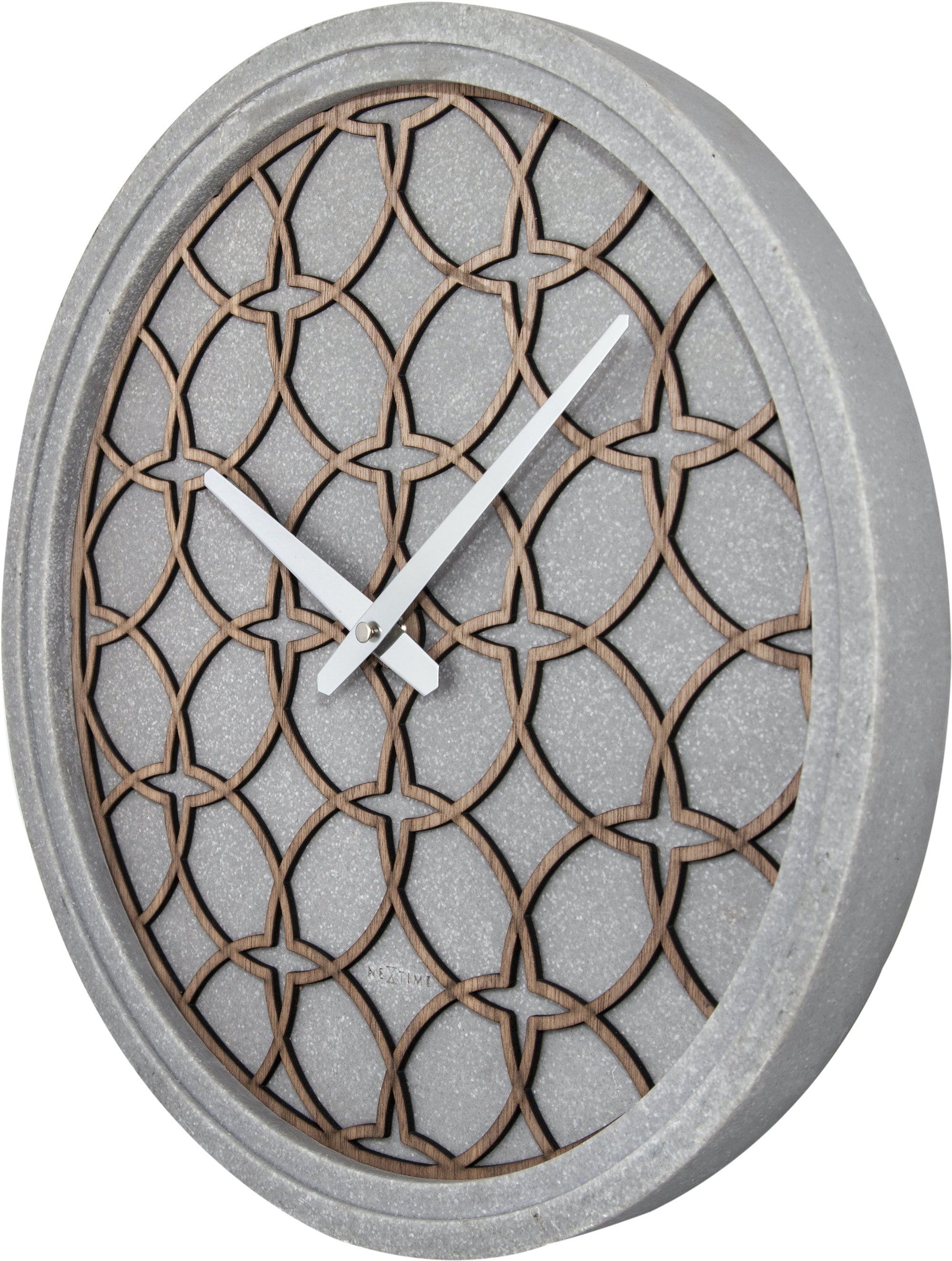Een moderne wandklok met een grijze betonrand en een houten, geometrisch patroon. Zilveren wijzers en het merk 'NEXTIME' zijn zichtbaar. Geschikt voor minimalistische interieurs en moderne woonkamers.