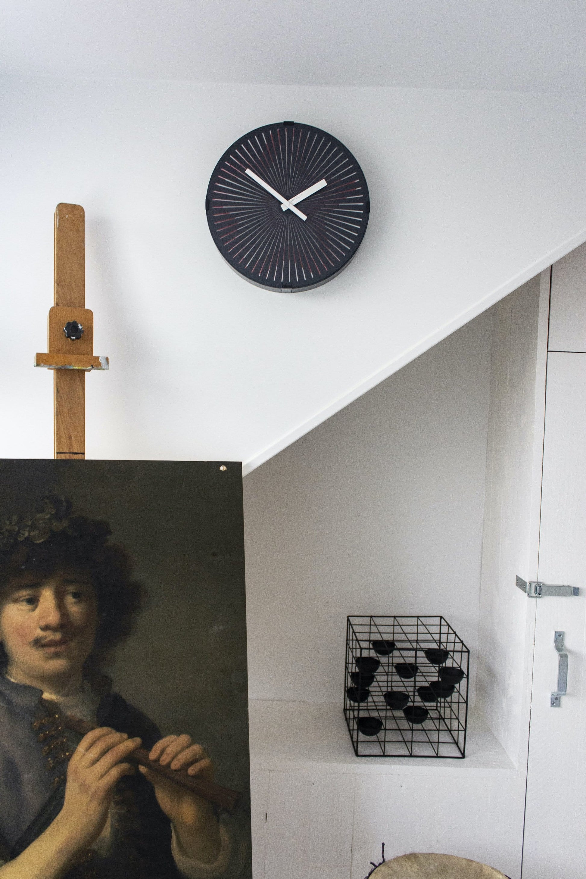Een moderne wandklok met donkerblauw oppervlak, witte en rode wijzers en stralenpatroon. Geschikt voor kantoor of woonkamer, met minimalistisch design en duidelijke tijdindicatie.