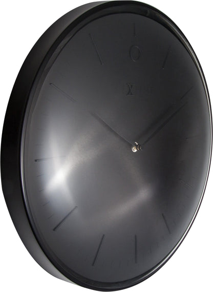 Een minimalistische, zwarte wandklok van Nextime met een glanzend wijzerplaat en dunne, zilverkleurige wijzers. Geschikt voor moderne interieurs en als decoratief element in woon- of kantoorruimtes.