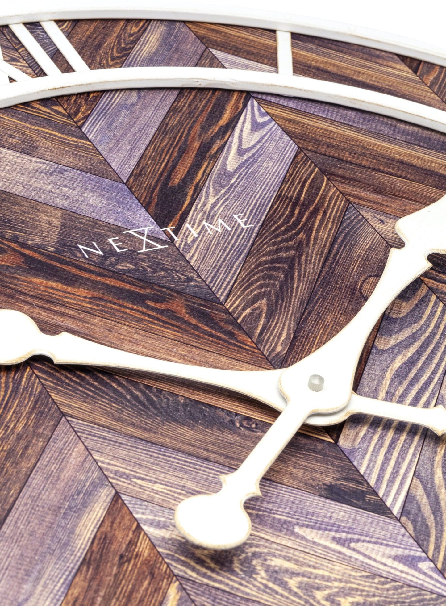 Een ronde wandklok met houten chevronpatroon en witte Romeinse cijfers. De witte wijzers en 'NEXTIME' merknaam zijn duidelijk zichtbaar. Ideaal voor een moderne woonkamer of kantoordecoratie.