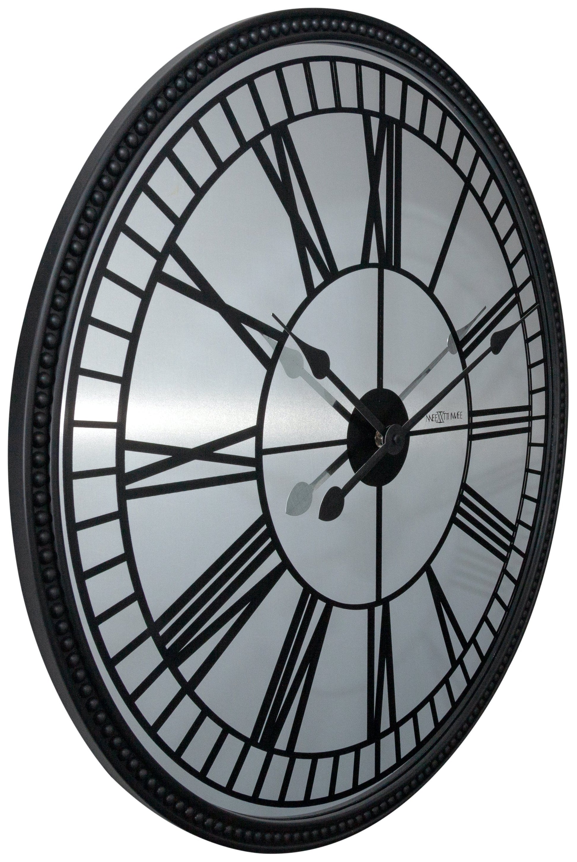 Een klassieke wandklok met zwart metalen kader en witte wijzerplaat met Romeinse cijfers. De wijzers en het merk 'NEXTIME' zijn duidelijk zichtbaar. Geschikt voor woonkamer of kantoordecoratie.