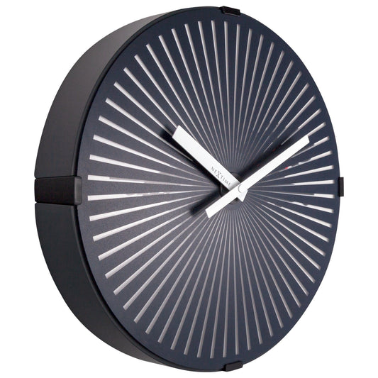 Een moderne, donkerblauwe wandklok van Nextime met witte, zonnestralen-achtige wijzers en een minimalistisch ontwerp. Perfect voor een stijlvolle kamerdecoratie of als kantooraccessoire.