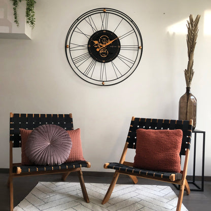 Een industriële wandklok met zwart metaalframe en zichtbare goudkleurige tandwielen, voorzien van drie koperen knoppen. Perfect voor een moderne woonkamer of kantoordecoratie.