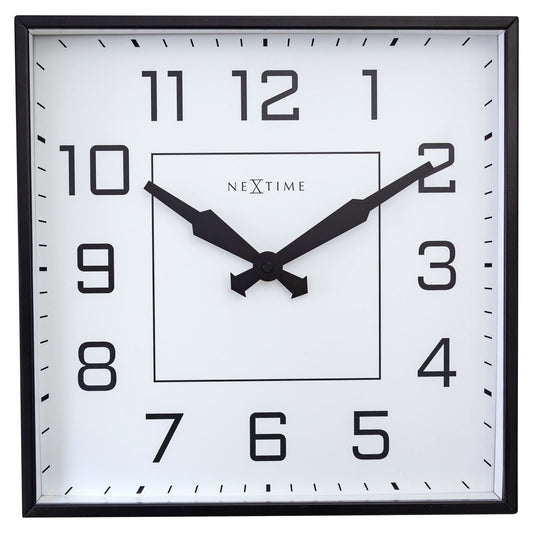 Een minimalistische, zwarte klok met witte wijzerplaat en duidelijke cijfers. De wijzers en kader zijn zwart, met het merk 'NEXtime' centraal. Ideaal voor moderne interieurs en kantoorruimtes.