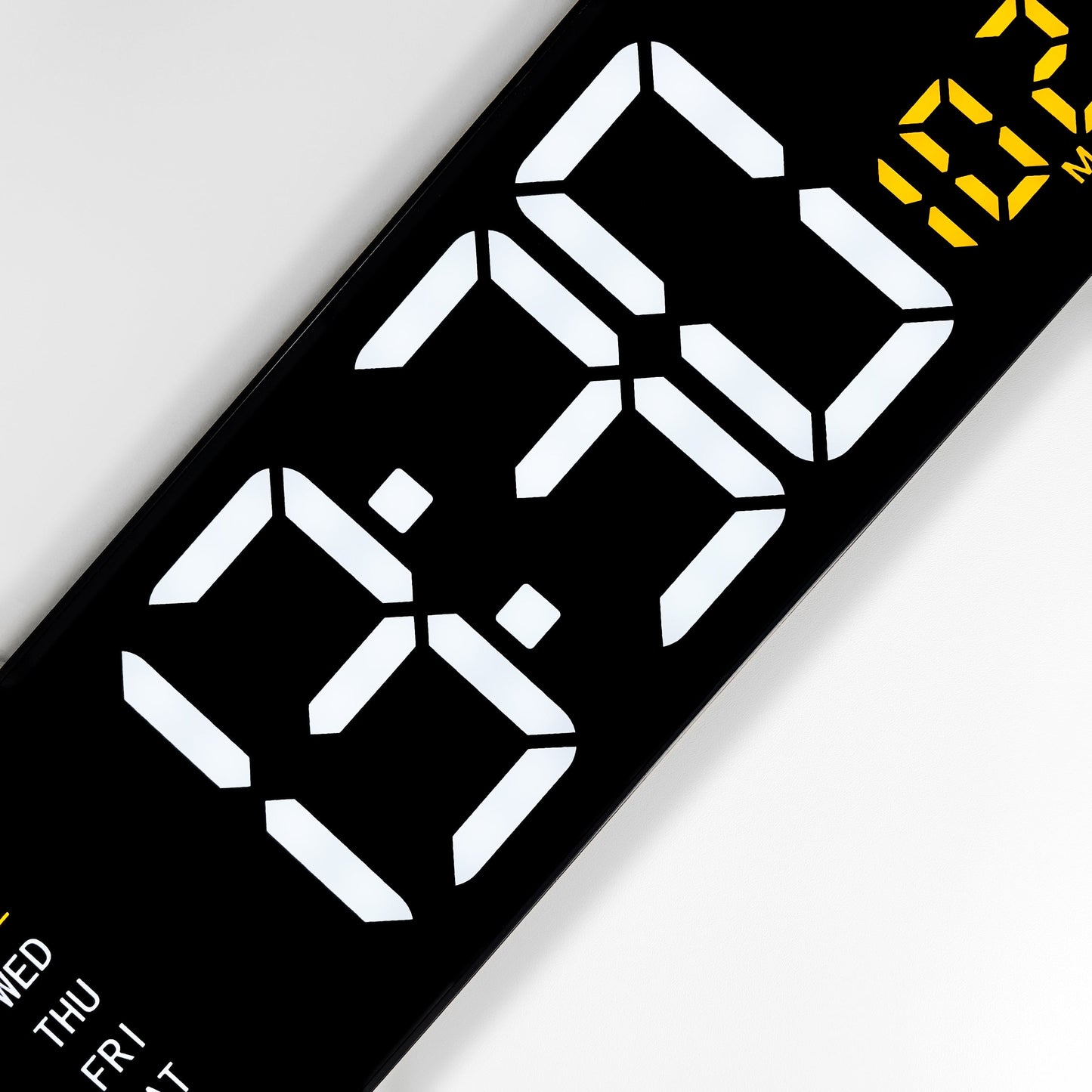 Een zwarte digitale wekker met witte tijd- en gele temperatuurweergave, toont 9:32 en 26°C. Inclusief dag van de week en datum, ideaal voor kantoor of slaapkamer.