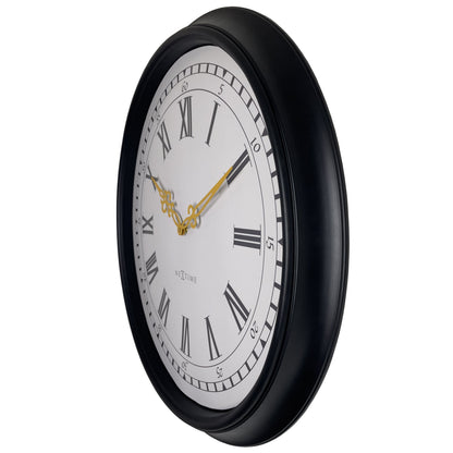 Een klassieke wandklok met zwart houten kader en witte wijzerplaat met Romeinse cijfers. Gouden wijzers en het merk 'NEXTIME' zijn duidelijk zichtbaar. Geschikt voor woonkamer of kantoordecoratie.