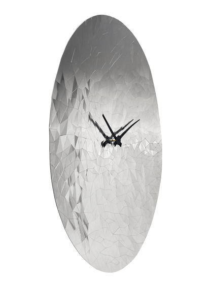 Een ronde, zilverkleurige wandklok met een facettenstructuur die lijkt op een diamant, voorzien van zwarte wijzers. Perfect voor moderne interieurs en als decoratief element in een woonkamer of kantoor.