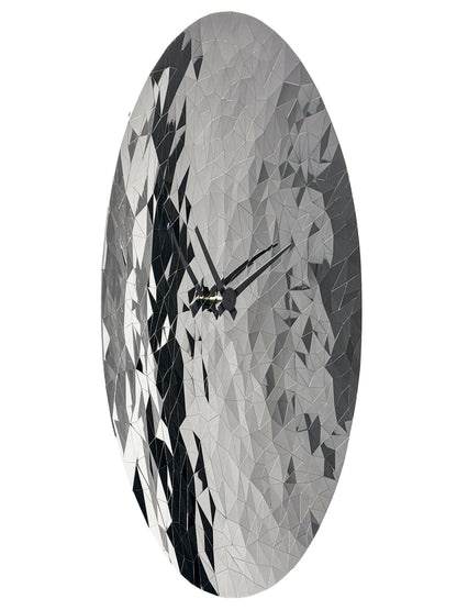 Een ronde, zilverkleurige wandklok met een facettenstructuur die lijkt op een diamant, voorzien van zwarte wijzers. Perfect voor een moderne woonkamer of kantoordecoratie met een luxe, reflecterende uitstraling.