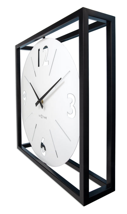 Een moderne wandklok met witte wijzerplaat en zwarte wijzers, ingebed in een zwart metalen kader. De klok heeft minimalistische cijfers en is geschikt voor woonkamer of kantoor.