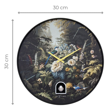 Een ronde wandklok met een gedetailleerd boslandschap, blauwe vogels en witte bloemen op donkere achtergrond, met gele wijzers en een wit vogelbeeldje. Perfect voor een natuurlijke, decoratieve woonkamer of slaapkamer.