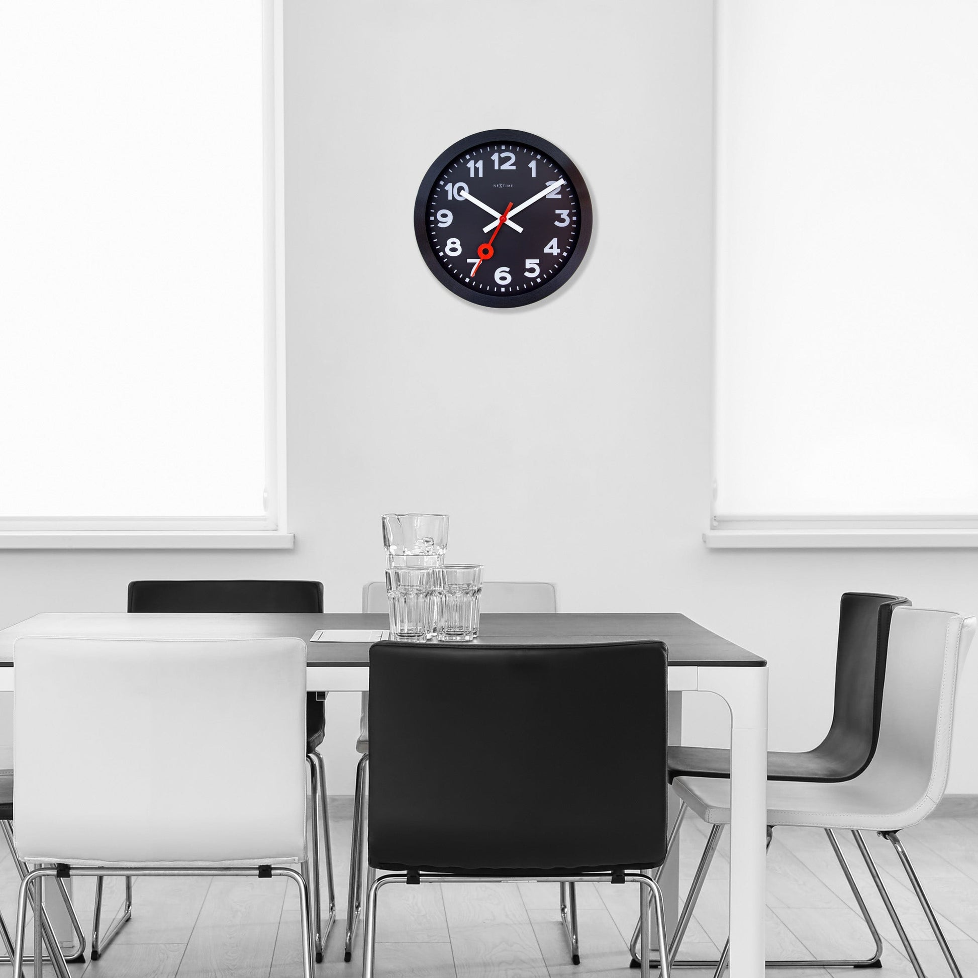 Een moderne wandklok met zwart frame en witte cijfers, voorzien van een opvallende rode secondewijzer. Geschikt voor kantoor of woonkamer, met minimalistisch design en duidelijke leesbaarheid.