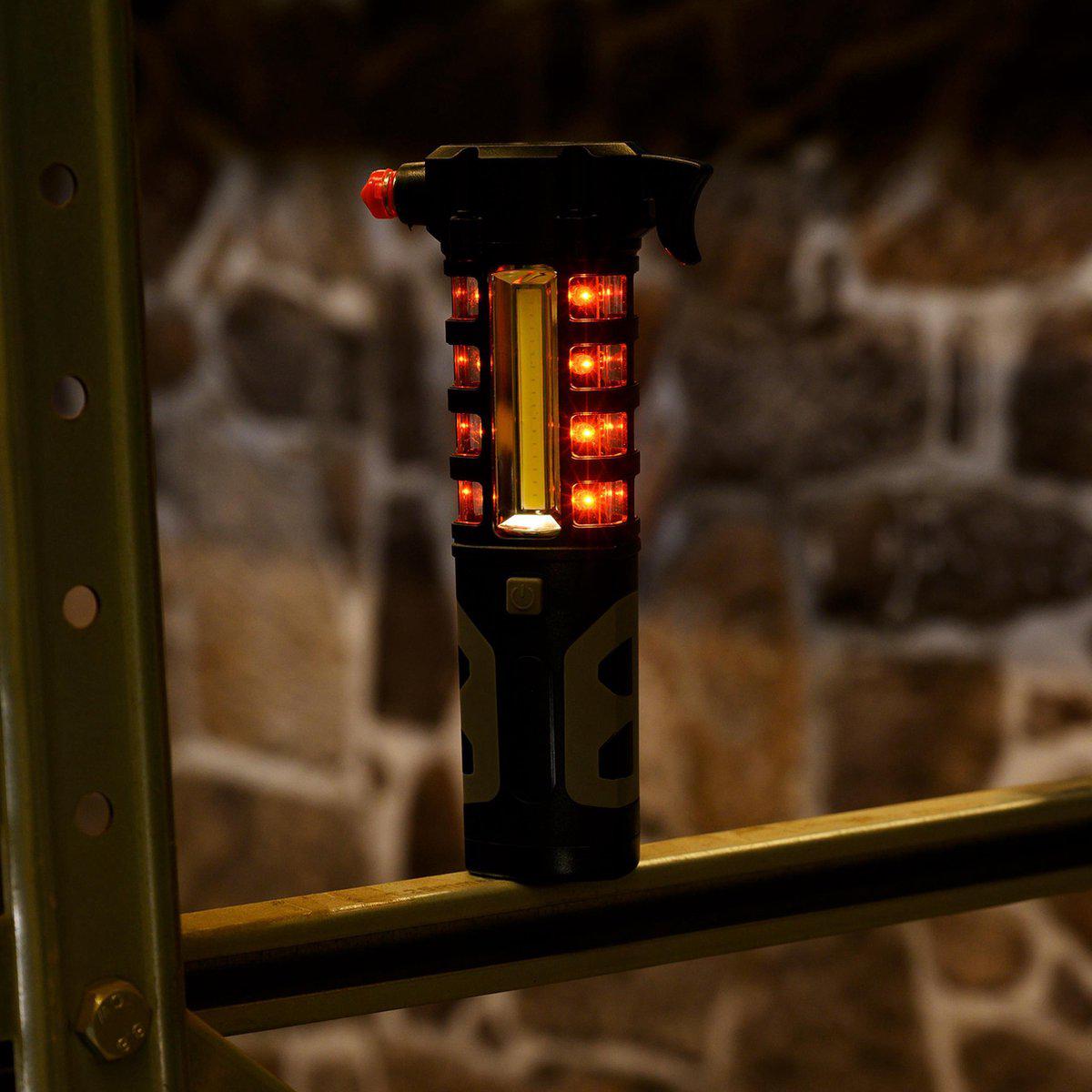 Zwart, robuust LED-lampje met rode knop en zichtbare batterijcompartiment, geschikt voor outdoor-activiteiten en noodsituaties. Compacte, waterdichte constructie met zichtbare schakelaar en reflecterende details.