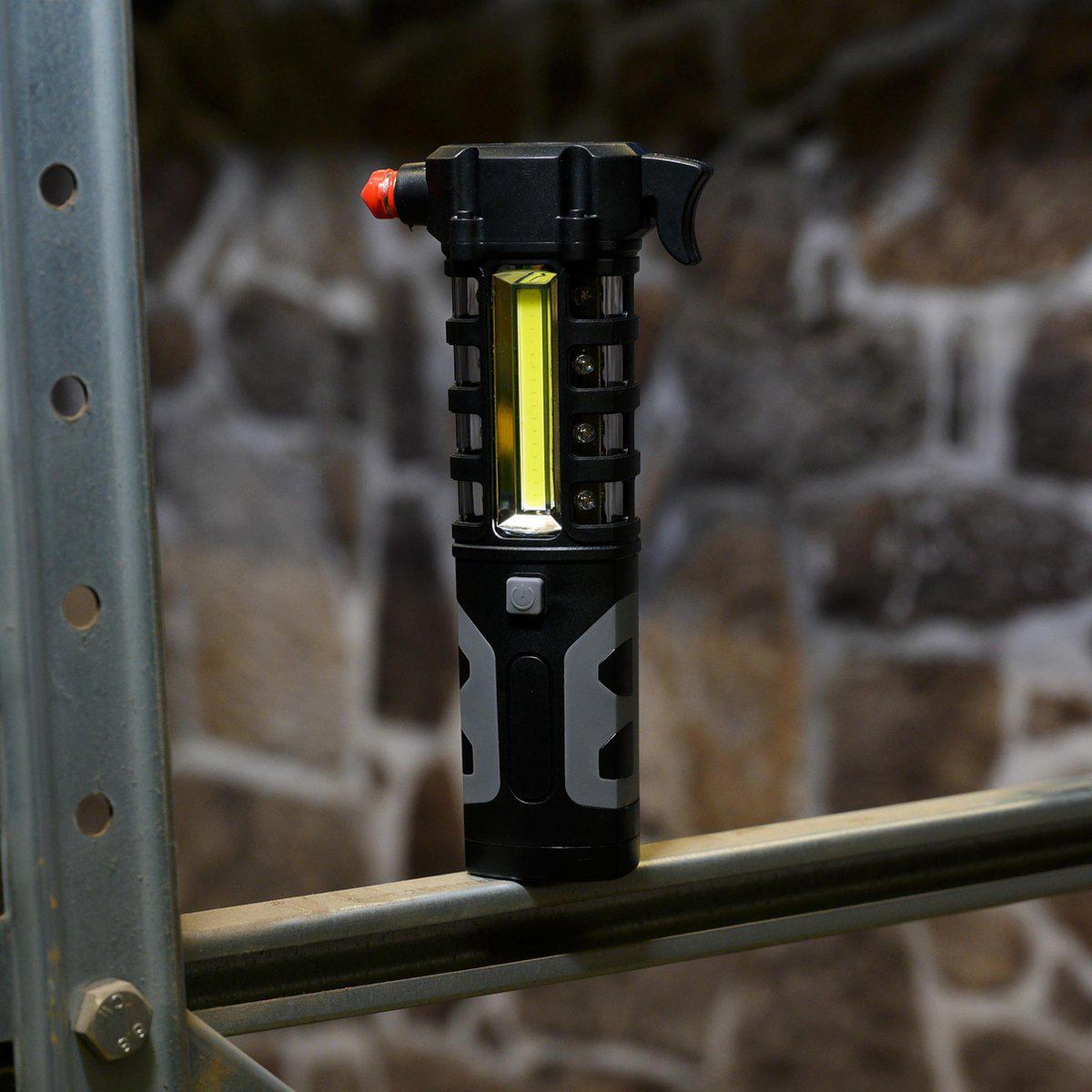 Zwart, robuust LED-lampje met rode knop en zichtbare batterijcompartiment, geschikt voor reparaties en noodverlichting. Gebruik als handlamp in werkplaats of buiten.