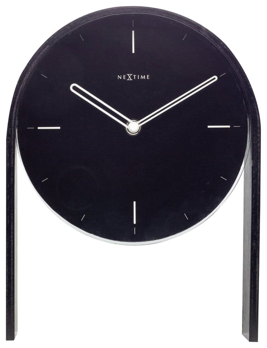 Een minimalistische zwarte wandklok van Nextime met witte wijzers en dunne markeringen, ondersteund door een elegante houten standaard. Perfect voor moderne interieurs en als decoratief element in woon- of kantoorruimtes.