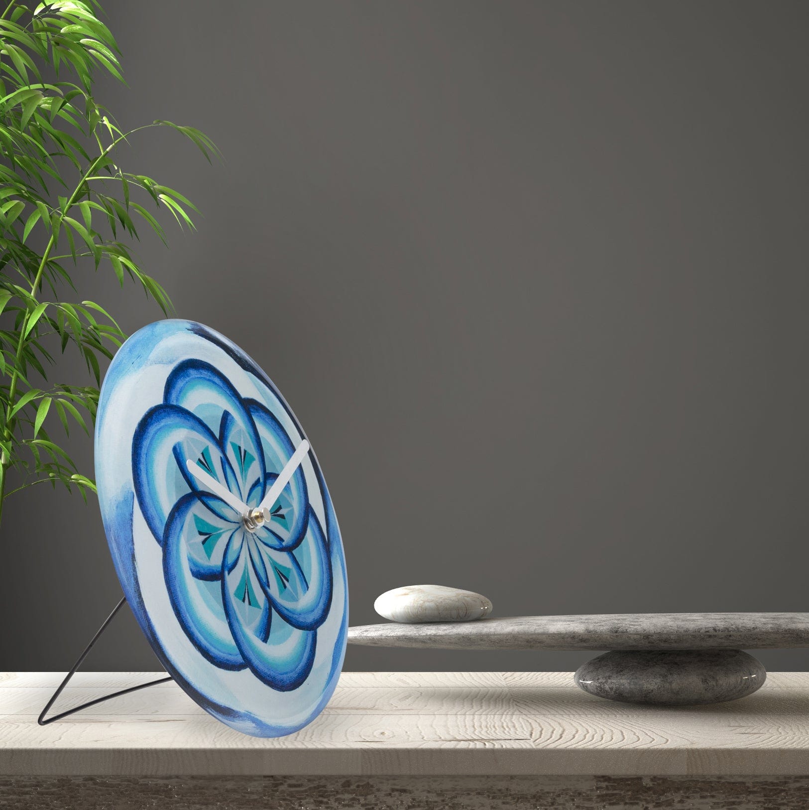 Een ronde wandklok met een blauwe bloemmotief, geschilderd in verschillende tinten blauw met zwarte contouren. Witte wijzers en een zilveren centrale beugel voor een moderne, decoratieve klok in woonkamer of slaapkamer.