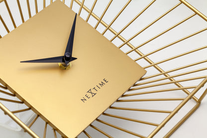 Een goudkleurige wandklok met een minimalistisch ontwerp, een vierkante kast van metaal met zichtbare zonnestralen, en zwarte wijzers. Geschikt voor moderne interieurs en als decoratief element in woon- of kantoorruimtes.