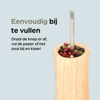 Houten pepermolen en zoutmolen van Hermanos, met goudkleurige doppen en FSC-certificering, geplaatst op een houten standaard met vervangbare doppen voor keukengebruik.