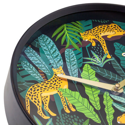 Een ronde wandklok met een zwart frame en een kleurrijk tropisch ontwerp van oranje leoparden tussen groene bladeren. Goudkleurige wijzers en een minimalistisch logo versterken de moderne, decoratieve stijl voor woonkamer of slaapkamer.
