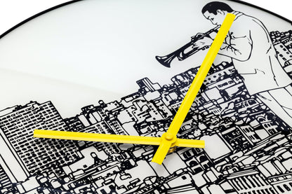 Een ronde wandklok met zwart-wit stadsillustratie en een man met trompet. Geel wijzerplaat en 'NEXTIME' merk. Perfect voor moderne interieurs of als decoratieve wandklok.