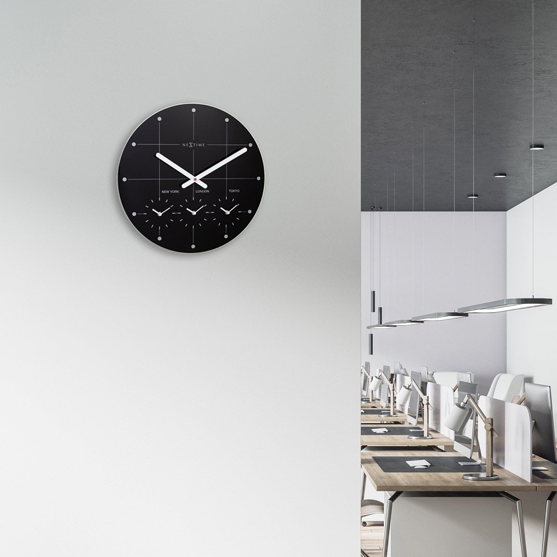 Een minimalistische witte wandklok van Nextime met zwarte wijzers en drie kleine wijzerplaten voor New York, Londen en Tokio, ideaal voor moderne interieurs en internationale tijdzone-beheer.